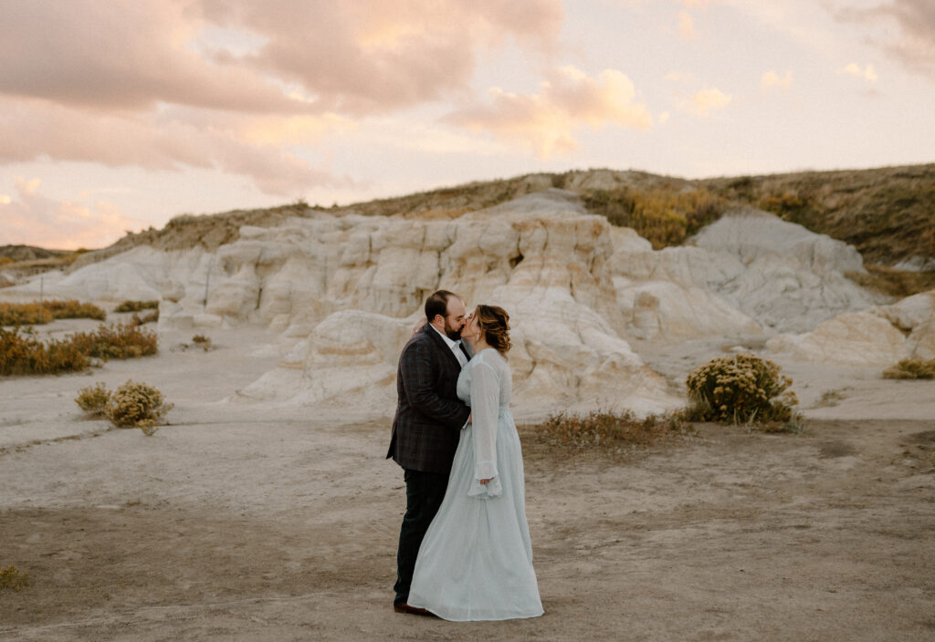 A bride and groom kisses at their at their intimate wedding ceremony at the Paint Mines Interpretive Park near Colorado Springs, Colorado 