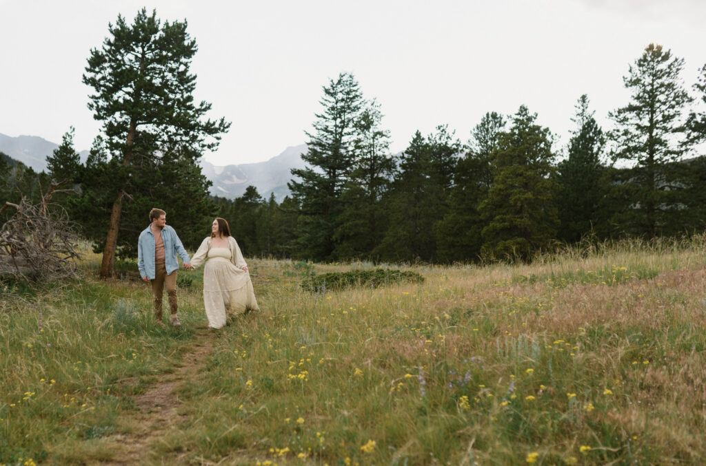 A couple holds hands at Sprague Lake inside Rocky Mountain National Park for their elopement near Estes Park, Colorado 