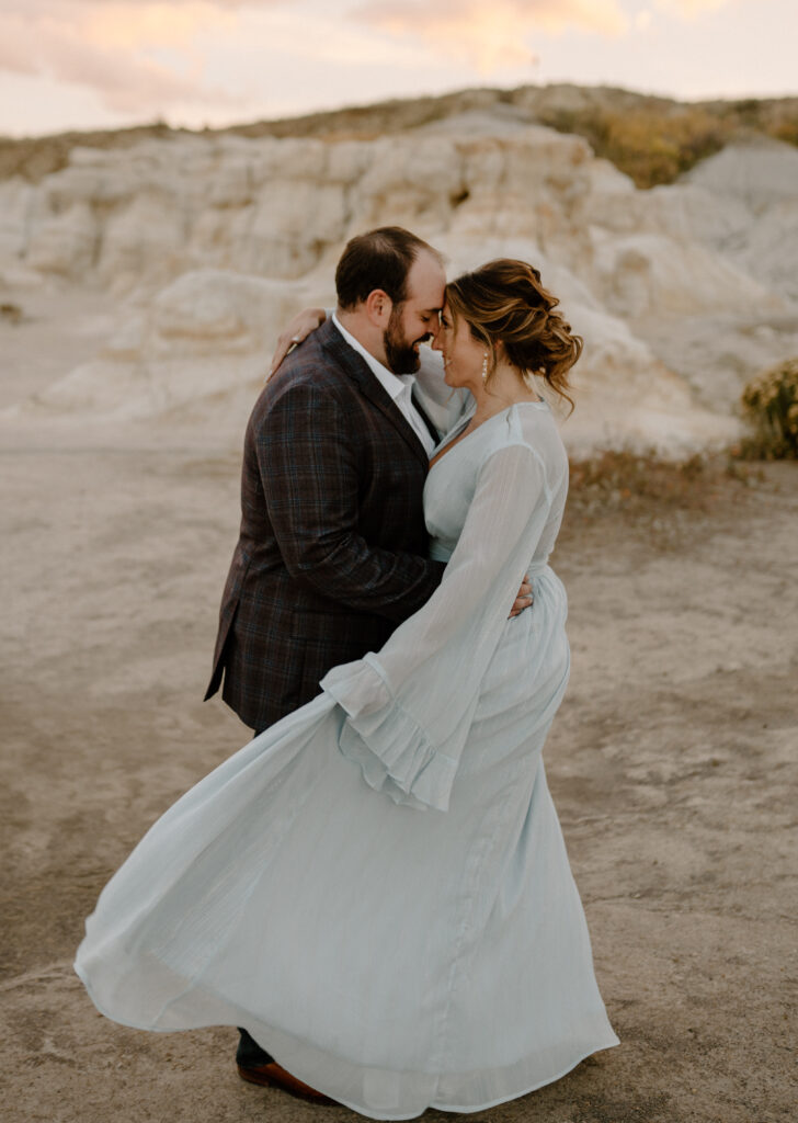 A couple embraces at their couples photos at Paint Mines Interpretive Park near Colorado Springs, Colorado. Find out what to wear for your destination engagement photos near Colorado Springs. 