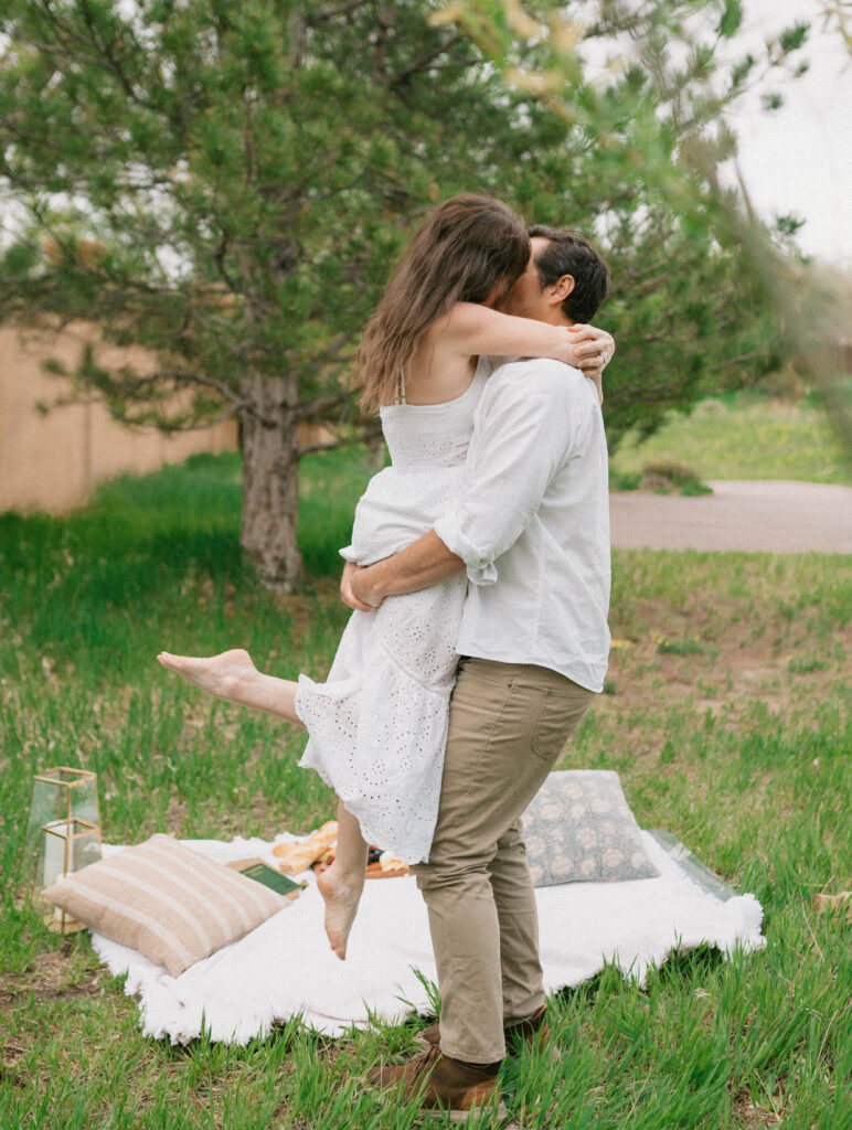 A couple dances together at a picnic for their engagement photos in Denver, Colorado. Learn how to choose the perfect outfit for engagement photos in Colorado.