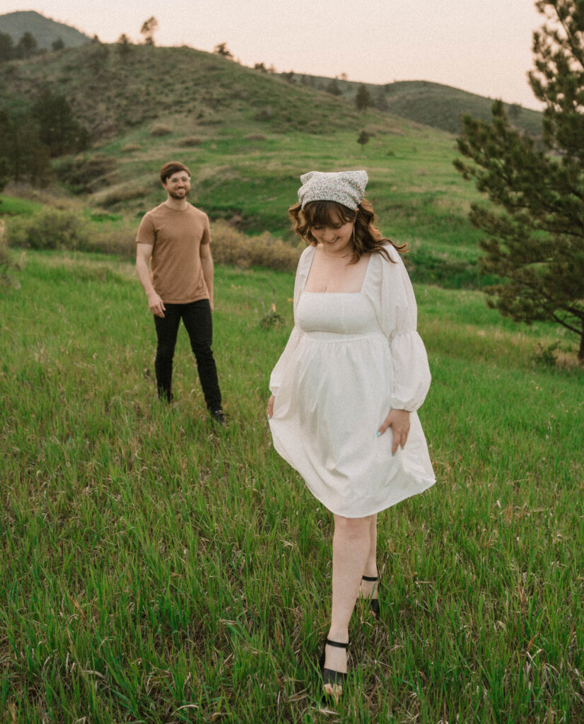 A couple walks at Lory State Park for their engagement photos in Northern Colorado. Learn how to pick an outfit for engagement photos in Colorado. 