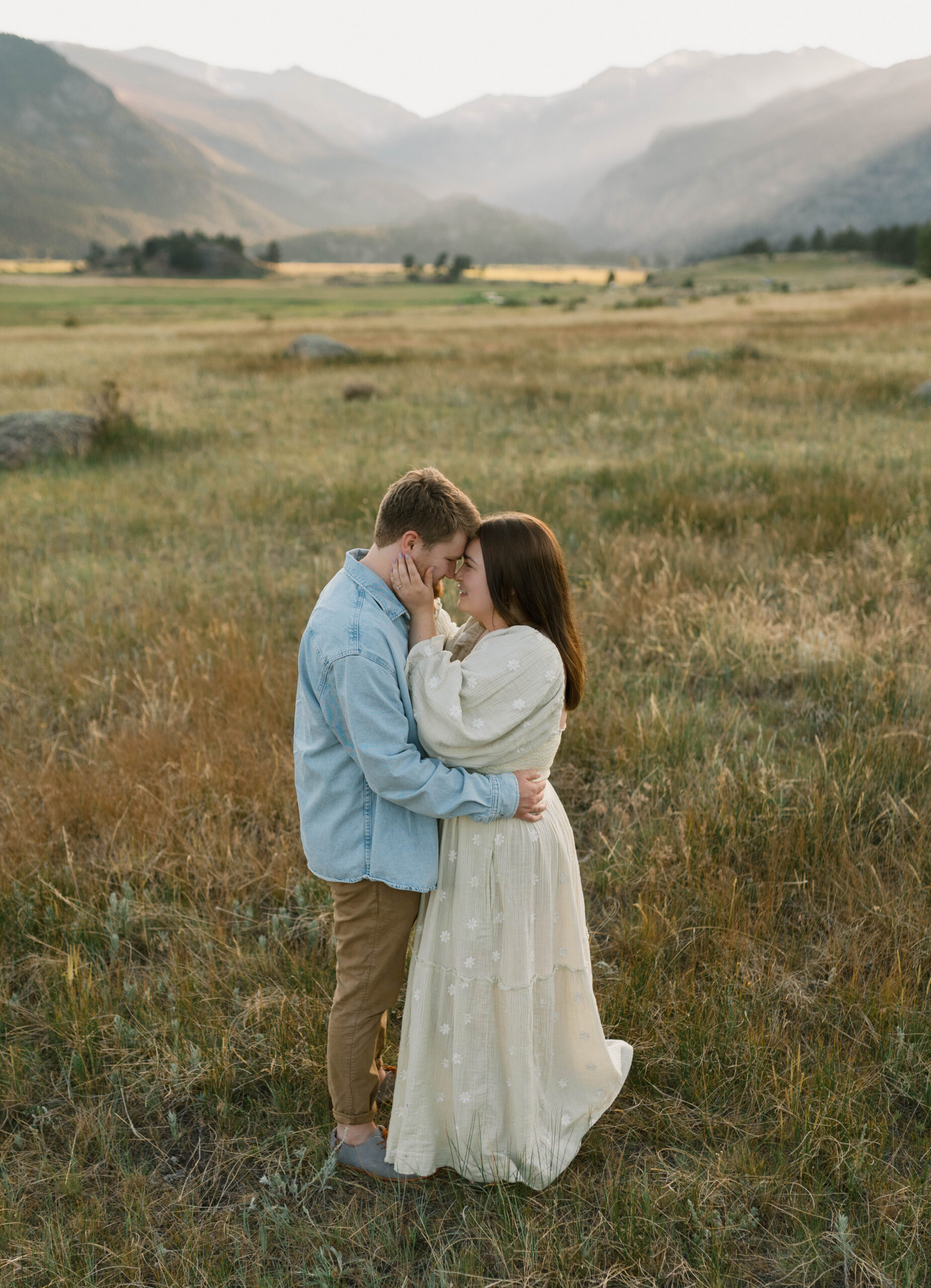 A couple kisses for couples photos at Moraine Park in Rocky Mountain National Park. Find out what to wear for your destination engagement photos near Estes Park, Colorado. 