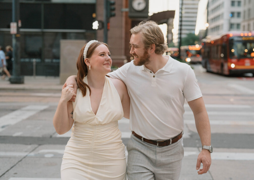 A couple walks in downtown Denver for city engagement photos. Learn how to choose what to wear for engagement photos near Denver, Colorado.