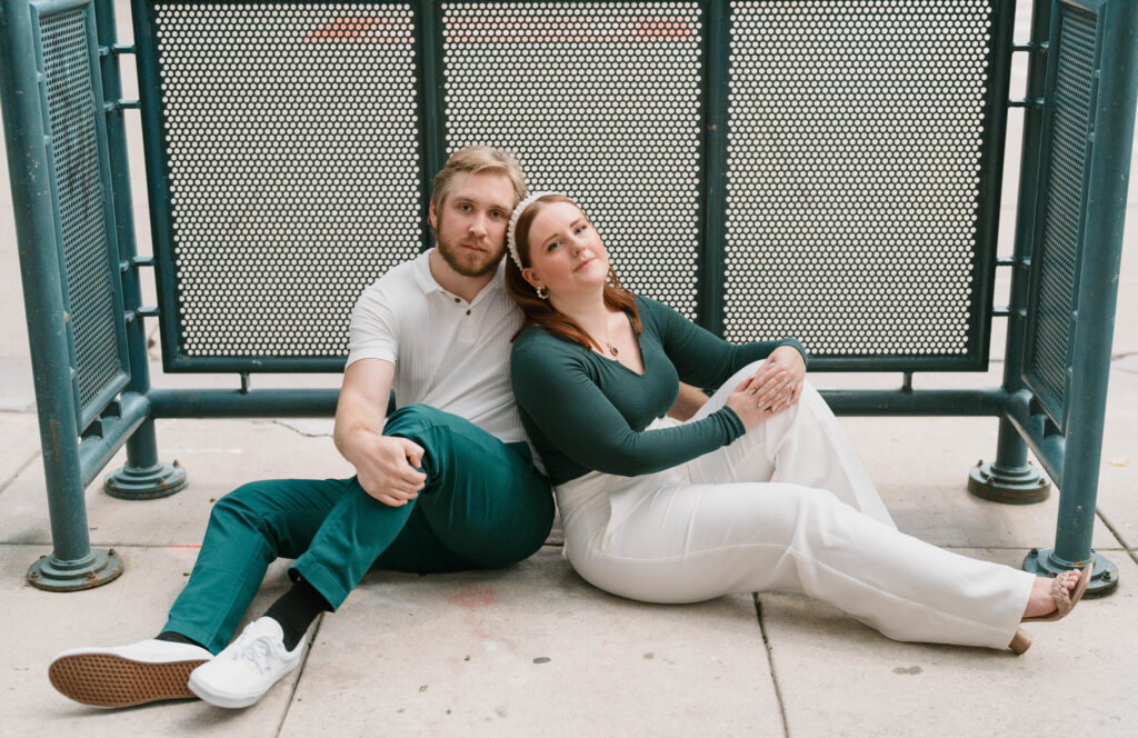 A couple poses in downtown Denver for engagement photos. Learn how to choose the perfect outfit for couples photos near Denver, Colorado.