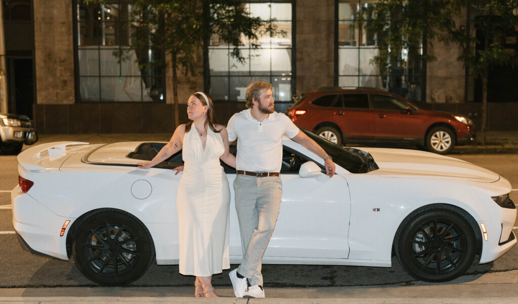 A couple poses in downtown Denver for city engagement photos at night. Learn how to choose what to wear for flash engagement photos in Colorado.