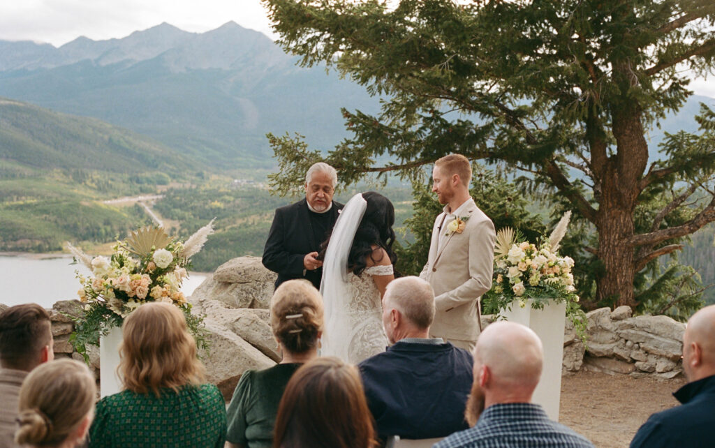 A candid photo of a bride a groom during their ceremony at Sapphire Point in Dillon, Colorado captured on 35mm film