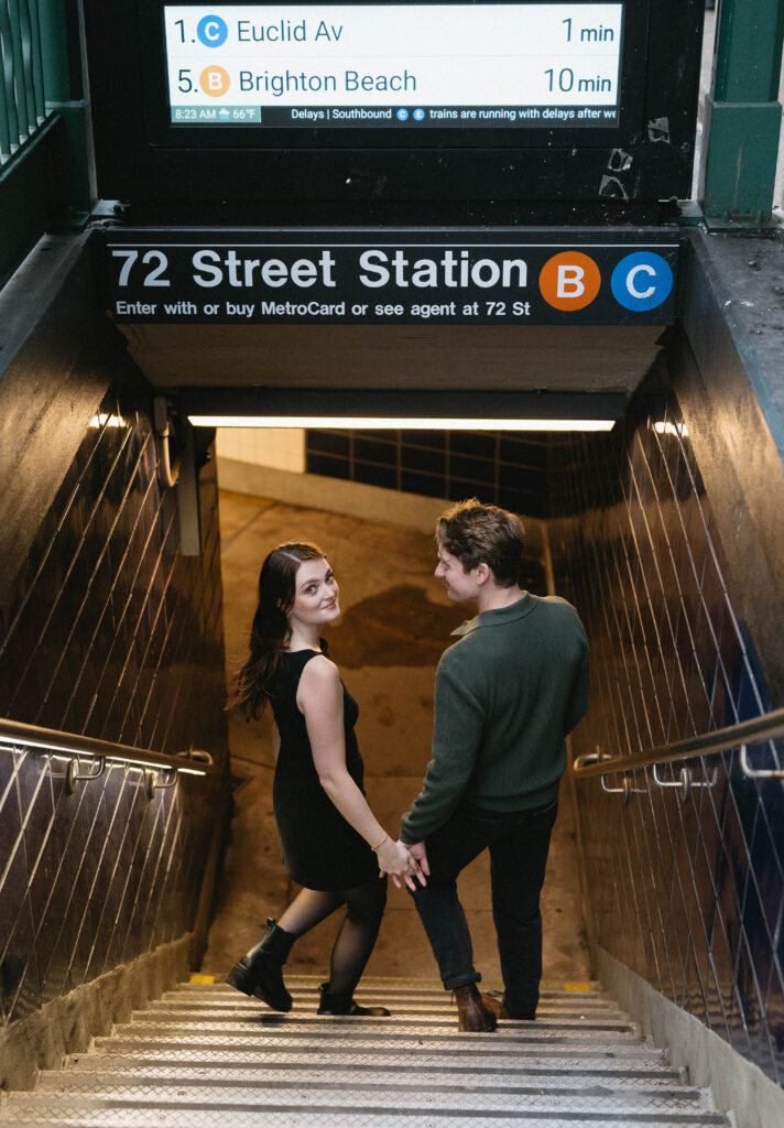 A documentary style photo of a candid moment between a couple entering the NYC subway station together during their engagement photo session. 