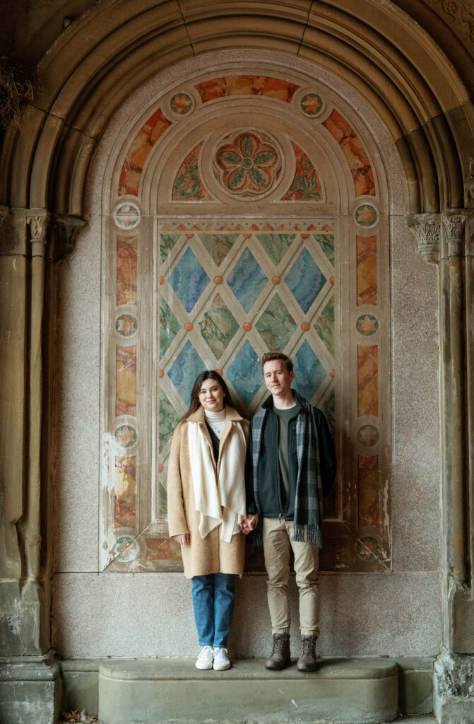 A couple poses for their engagement photos inside The Arcade at Bethesda Terrace and Fountain in Central Park. 