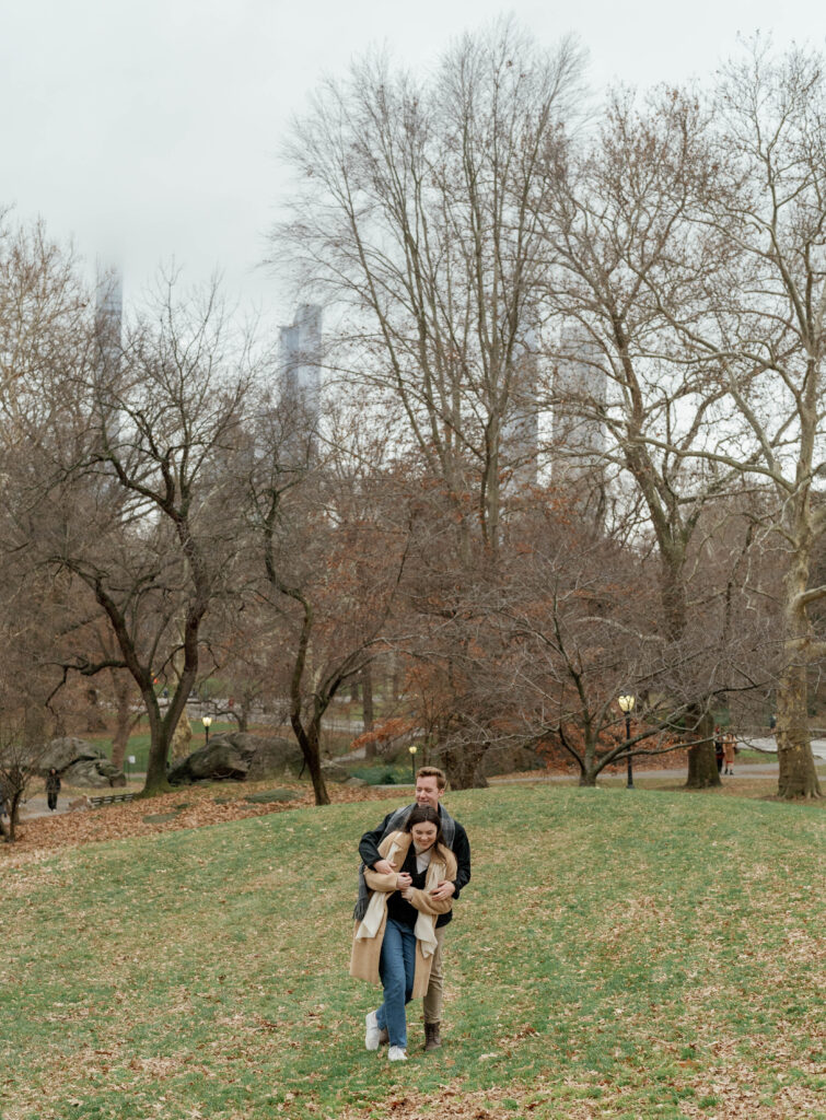 A couple embraces in Central Park. Discover documentary engagement photography in New York City.  