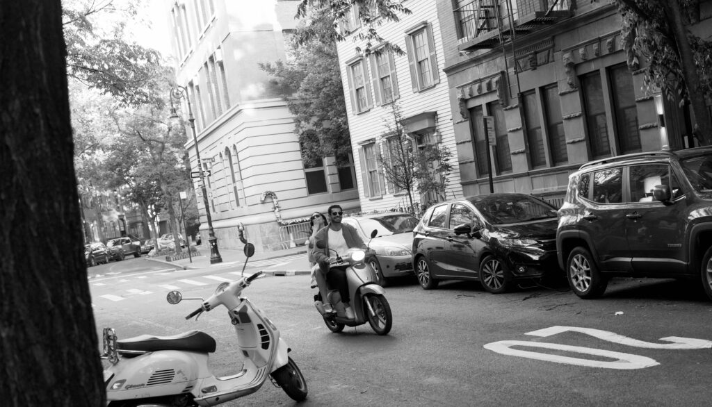 Stylish couple riding a scooter in the West Village for their NYC engagement photos. Discover documentary engagement photography in New York City. 