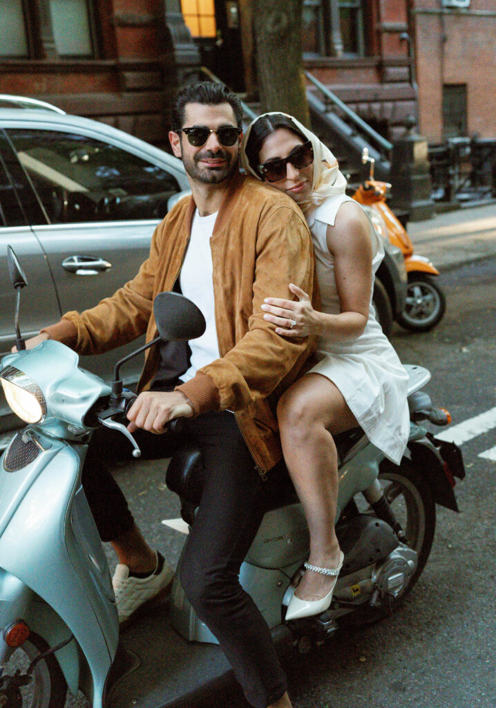 Stylish couple riding a scooter in the West Village for their NYC engagement photos. Discover documentary engagement photography in New York City. 