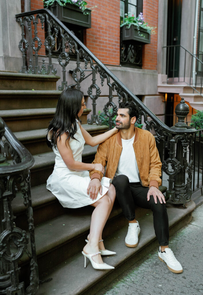 Fashionable bride-to-be in Jimmy Choos. Engaged couple posing in front of a historic West Village brownstone. Discover Documentary Engagement Photography in New York City. 