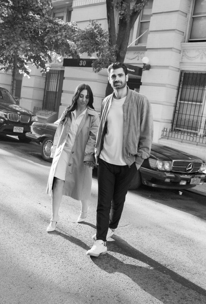 Engaged couple posing in front of a vintage car in the West Village in NYC. Discover timeless engagement photography in New York City. 