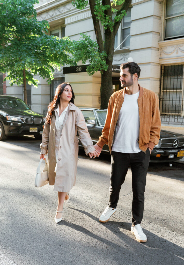 Engaged couple posing in front of a vintage car in the West Village in NYC. Discover timeless engagement photography in New York City. 