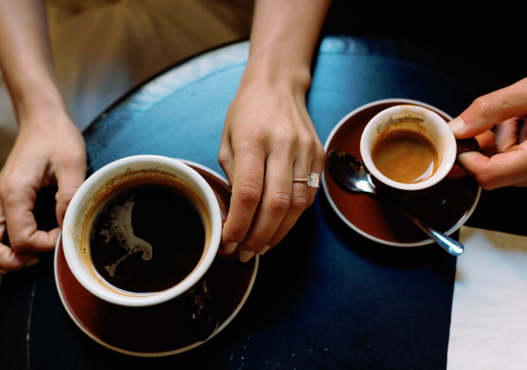 Candid moment of engaged couple at a cozy West Village coffee shop in NYC. Discover documentary and editorial New York City engagement photos. 