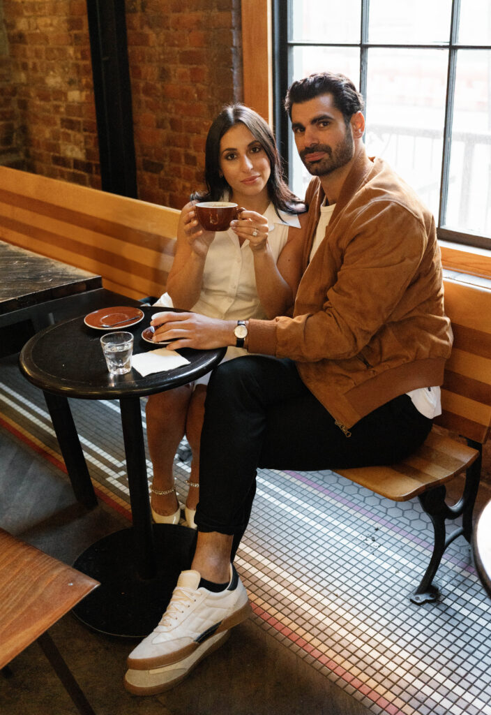 Candid moment of engaged couple at a cozy West Village coffee shop in NYC. Discover documentary and editorial New York City engagement photos. 