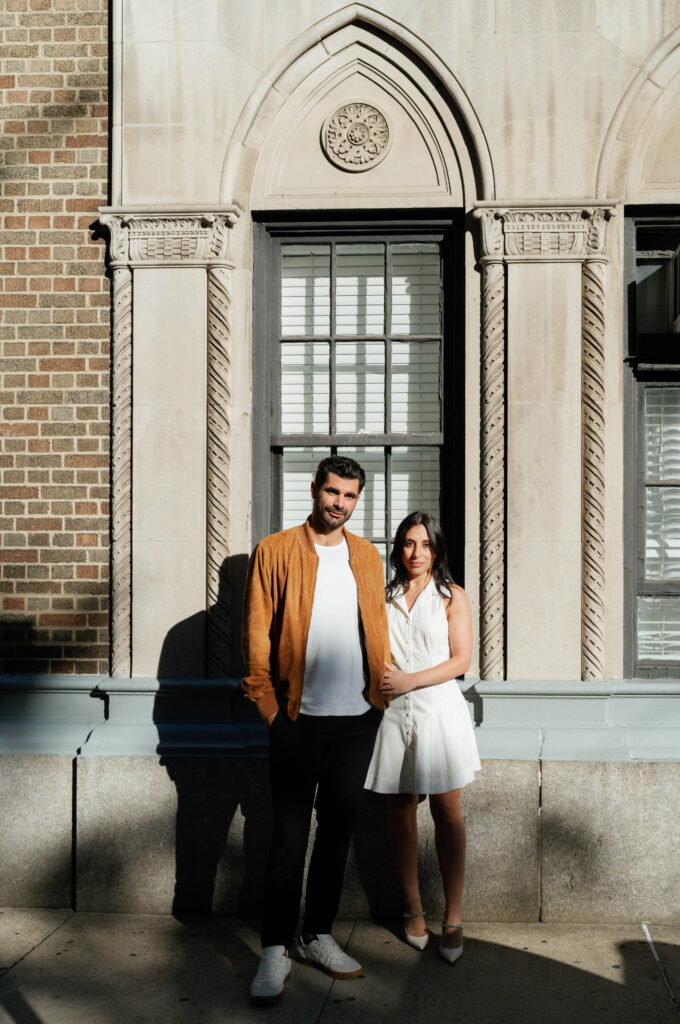 Romantic moment between engaged couple in front of iconic Greenwich Village building. Discover intimate and documentary engagement photos in New York City. 