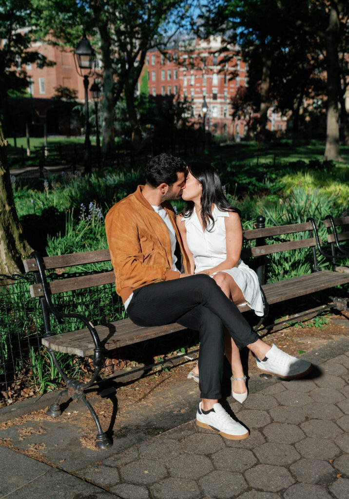 Romantic kiss between engaged couple at Washington Square Park in NYC. Discover intimate and documentary engagement photos in New York City. 