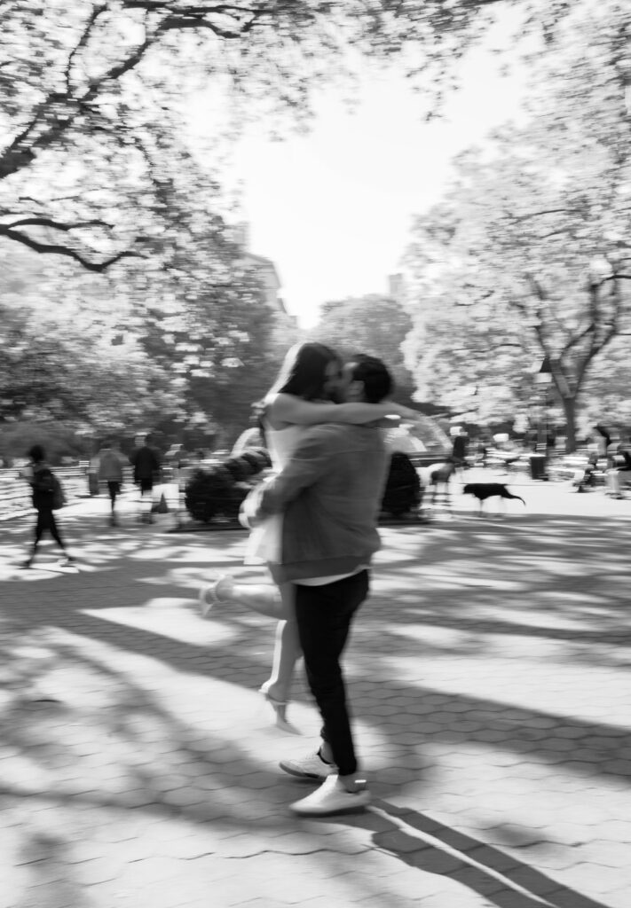 Romantic kiss between engaged couple at Washington Square Park in NYC. Discover intimate and documentary engagement photos in New York City. 