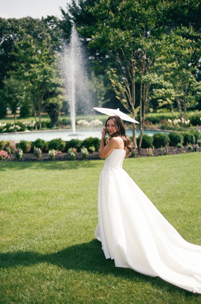 A candid photo of a bride with a parasol on 35mm film. Discover documentary film wedding photography in New York City.