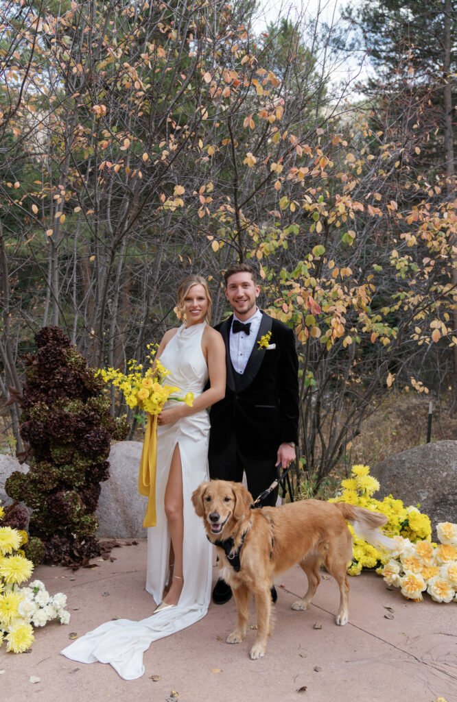 A couple poses near their fall wedding florals in Vail. Discover yellow wedding inspiration and luxury wedding photography in Colorado and beyond.  